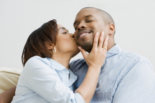 African American woman kissing husband on cheek